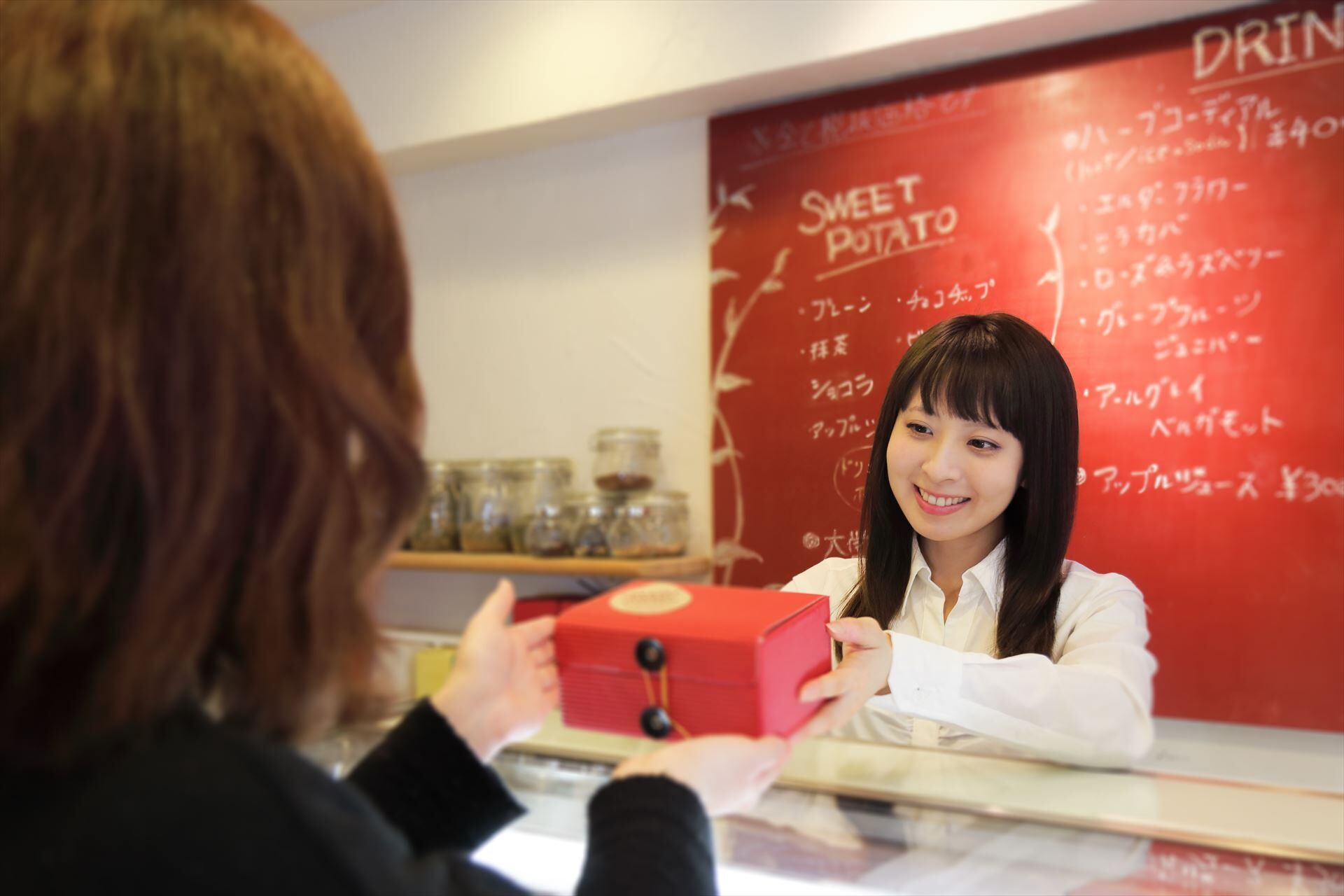 お菓子を渡すスタッフ